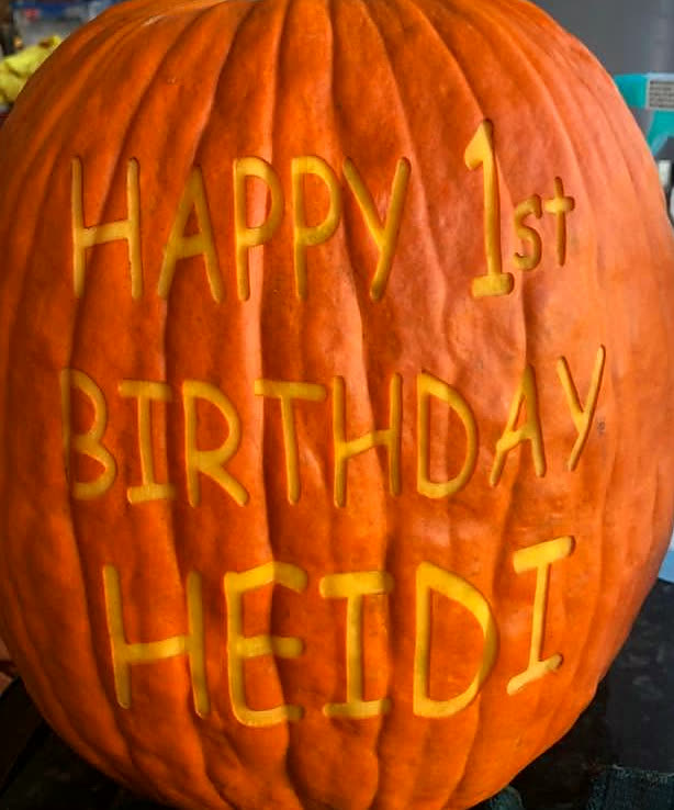 A pumpkin laser-engraved with Happy 1st Birthday Heidi